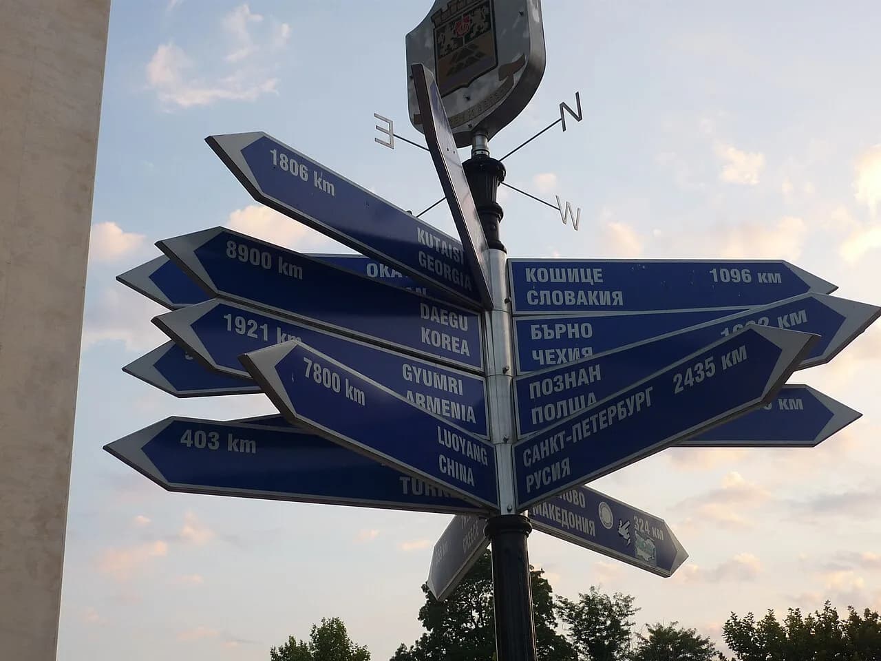 A signpost in Plovdiv showing city names in Bulgarian Cyrillic and Latin letters