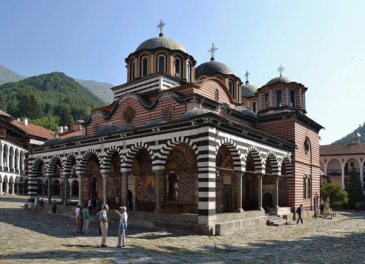 The striped church and mountain courtyard of Rila Monastery